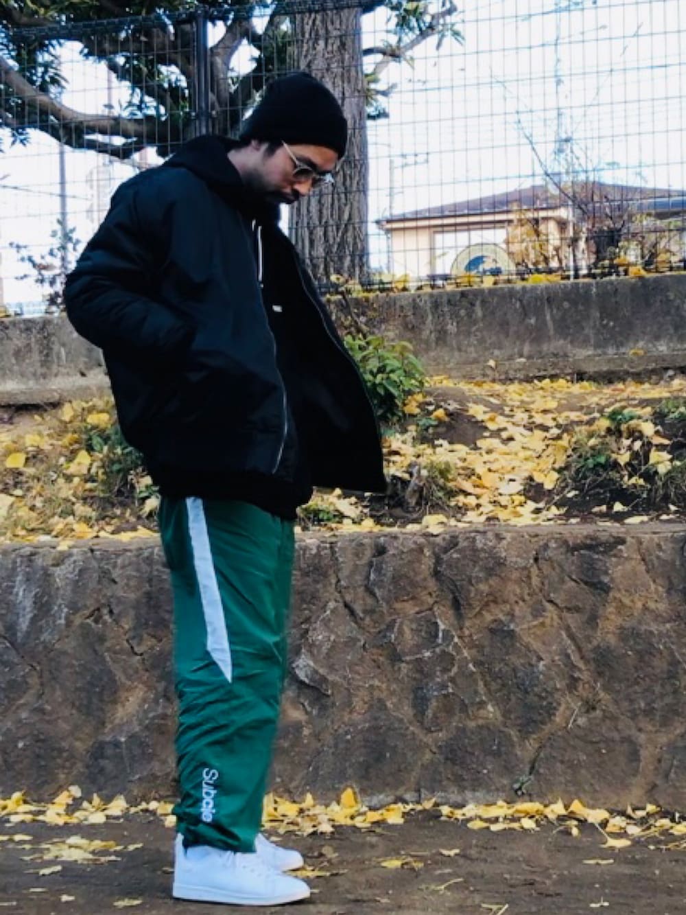 ブラック系のMA-1、グリーン系のその他パンツ、ホワイト系のスニーカーを着用したメンズの冬コーディネートの2枚目の写真