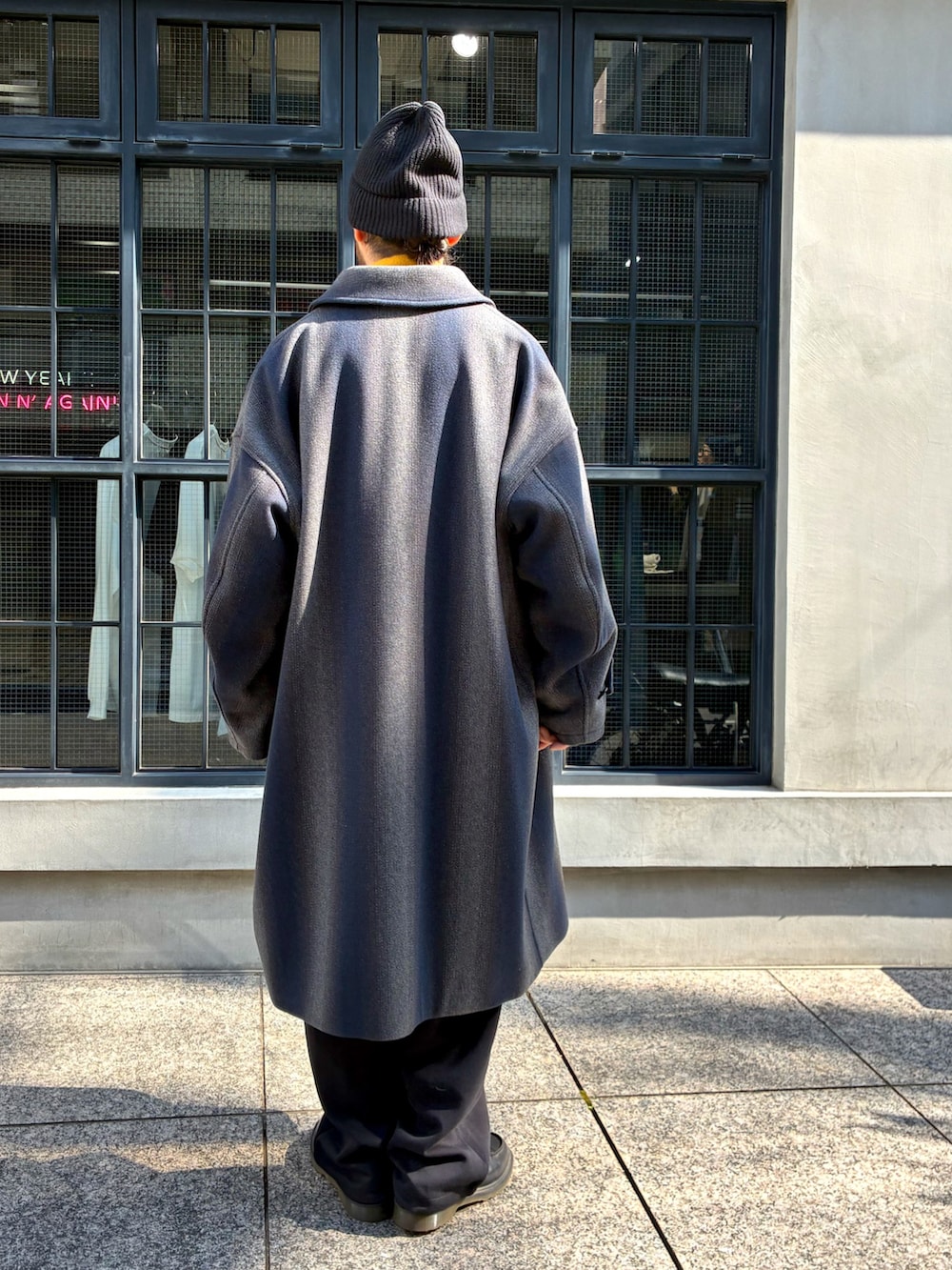 ブラック系のローファー、その他のチェスターコート、ブラック系のニットキャップ/ビーニーを着用したメンズの冬コーディネートの2枚目の写真