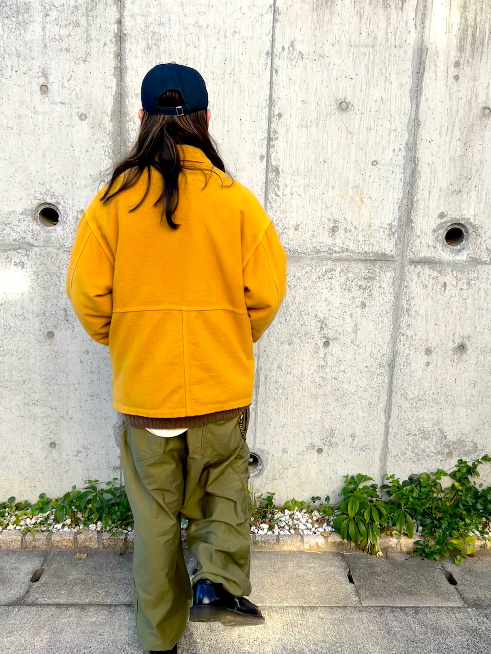 イエロー系のカバーオール、グリーン系のカーゴパンツ、ブラック系のローファーを着用したメンズの冬コーディネートの3枚目の写真