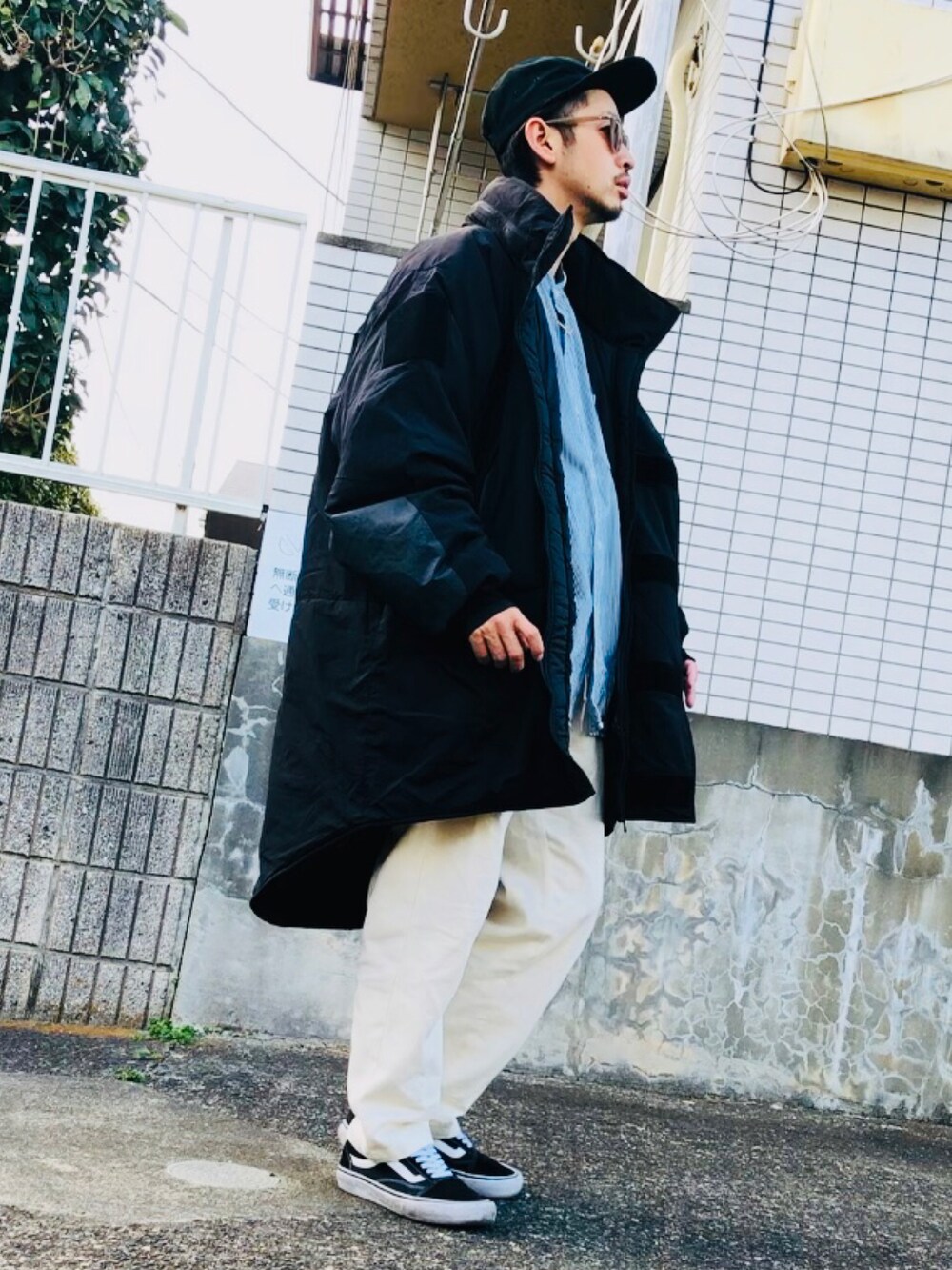 ブラック系のミリタリージャケット、ホワイト系のその他パンツ、ブラック系のスニーカーを着用したメンズの春コーディネートの2枚目の写真