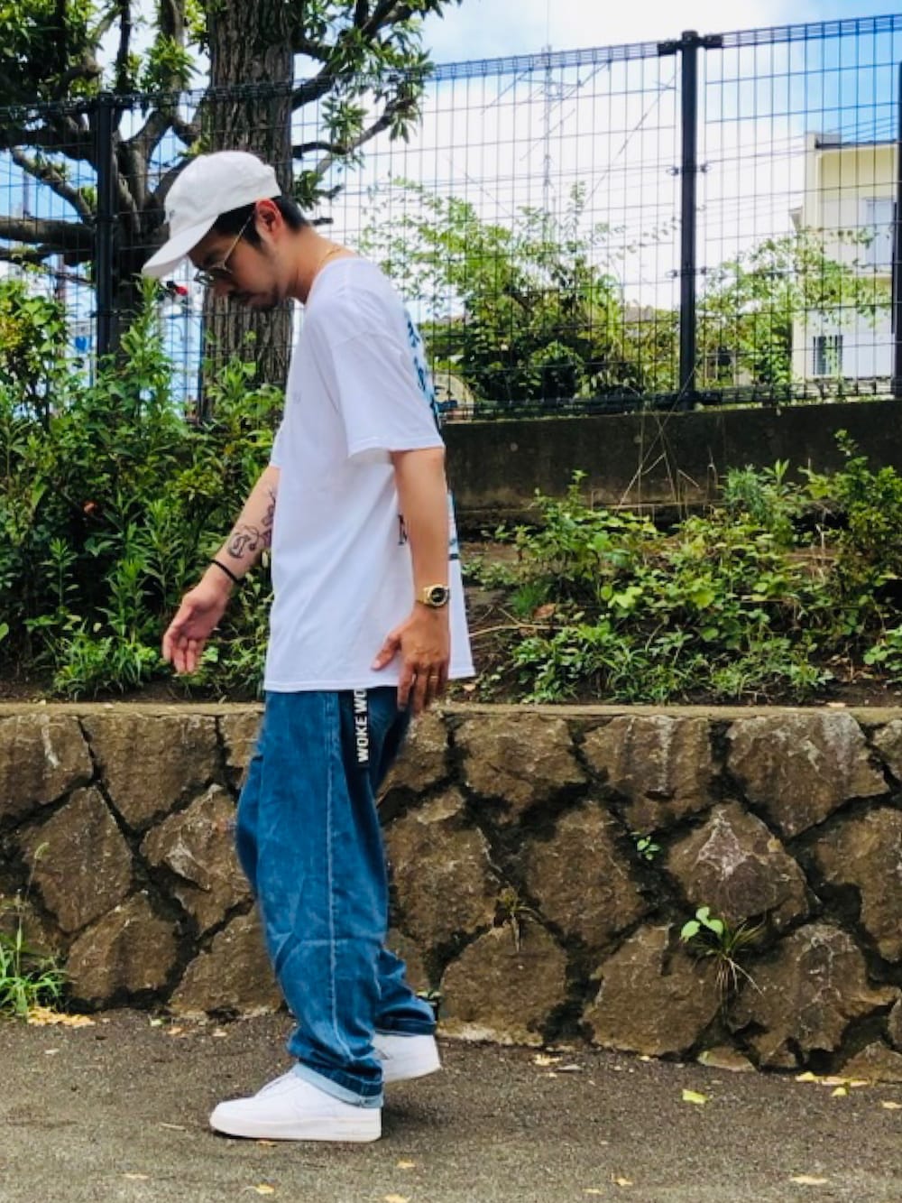 ブルー系のその他パンツ、ホワイト系のスニーカー、ホワイト系のキャップを着用したメンズの夏コーディネートの2枚目の写真