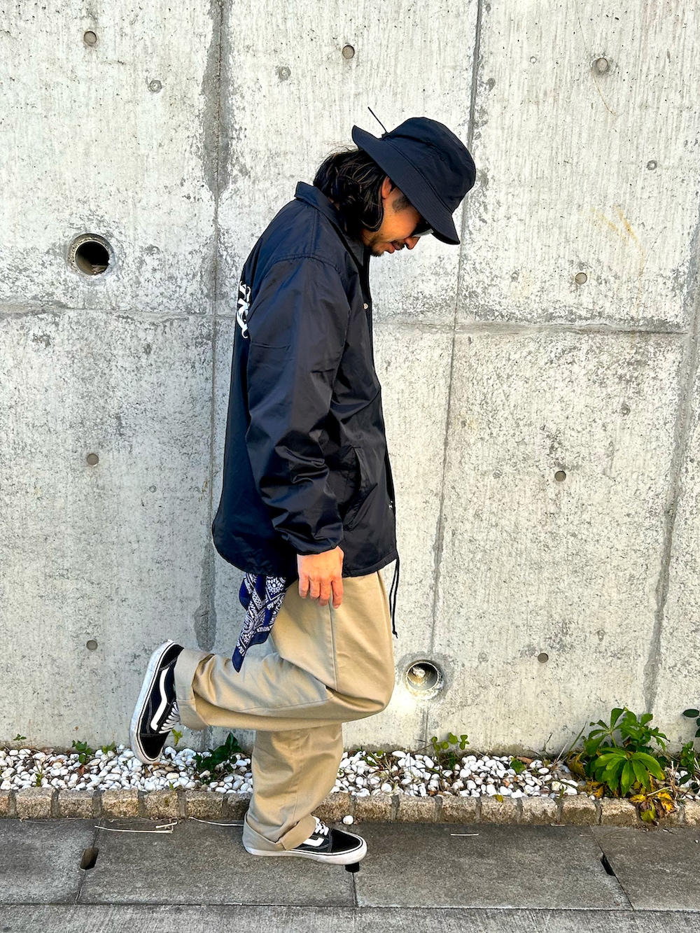 ブラック系のスニーカー、ベージュ系のチノパンツ、ブラック系のジャケット/アウターを着用したメンズの冬コーディネートの2枚目の写真