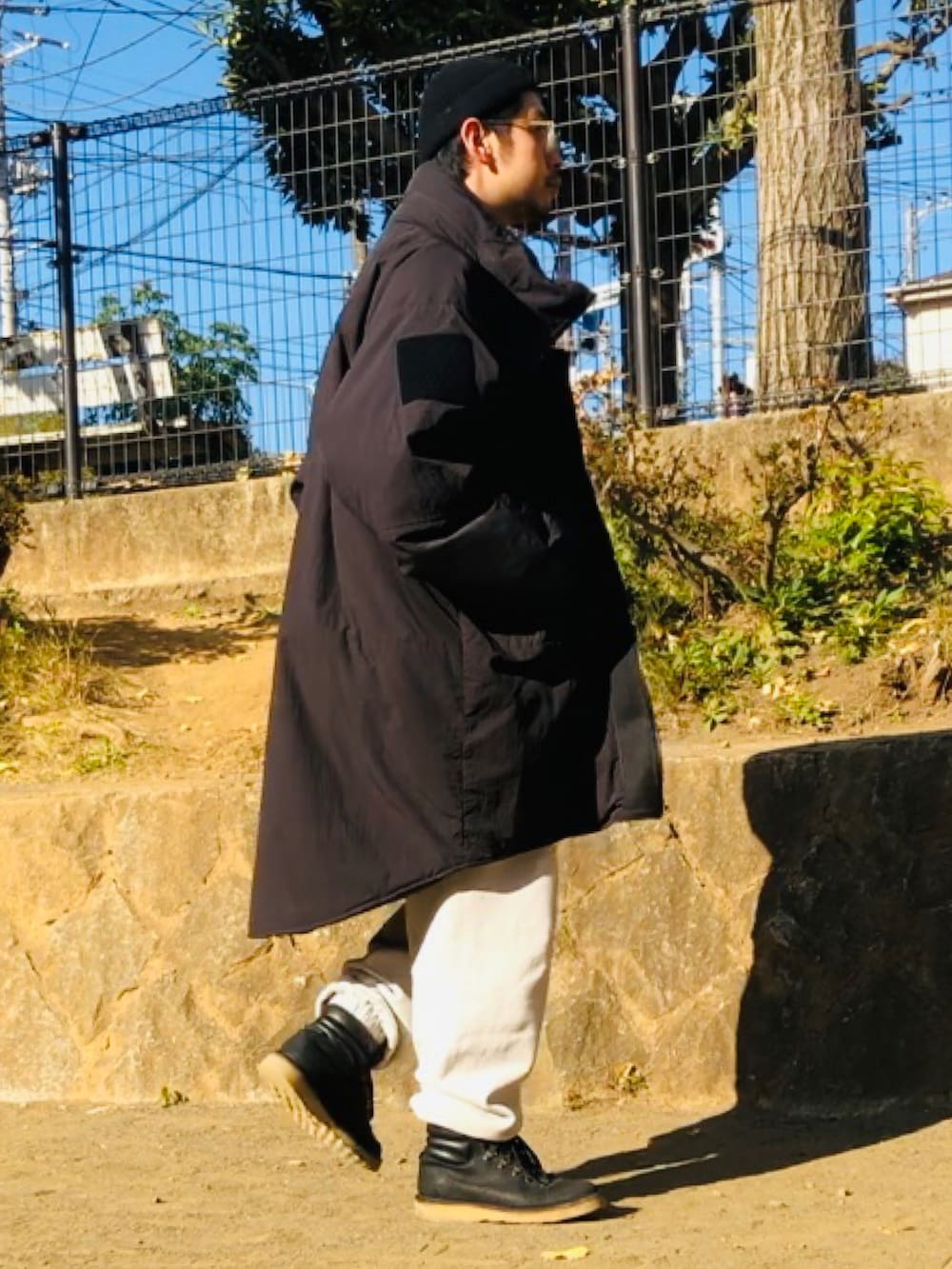 グレー系のスウェットパンツ、ブラック系のブーツ、ブラック系のミリタリージャケットを着用したメンズの冬コーディネートの2枚目の写真