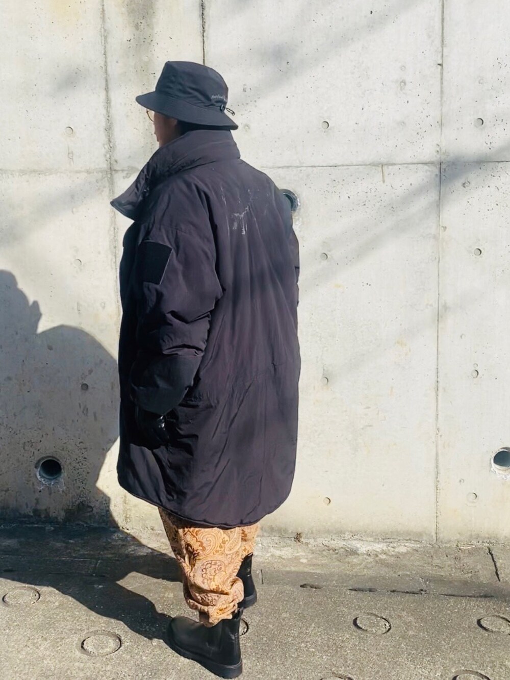 ベージュ系のジャケット/アウター、ベージュ系のその他パンツ、ブラック系のミリタリージャケットを着用したメンズの冬コーディネートの4枚目の写真