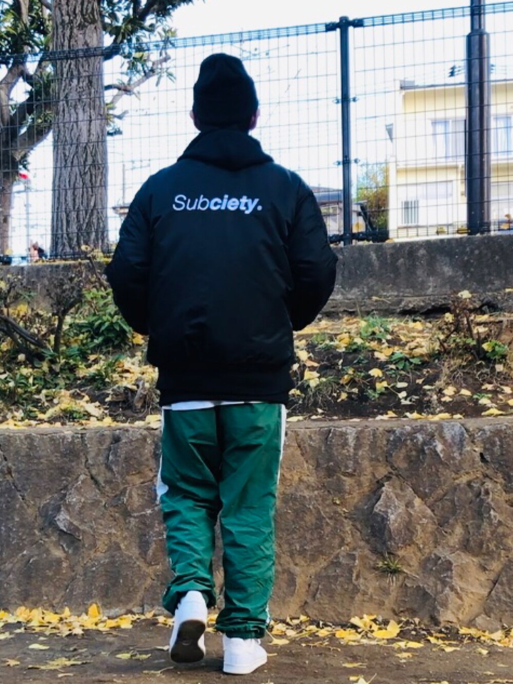 ブラック系のMA-1、グリーン系のその他パンツ、ホワイト系のスニーカーを着用したメンズの冬コーディネートの3枚目の写真