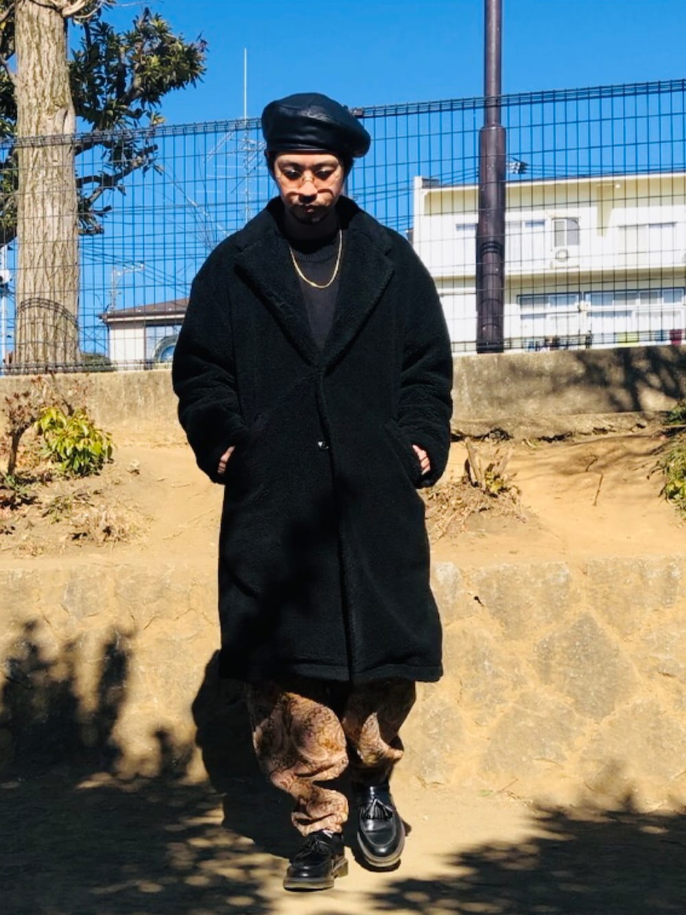 ブラック系のニット/セーター、ベージュ系のその他パンツ、ブラック系のその他アウターを着用したメンズの冬コーディネートの2枚目の写真