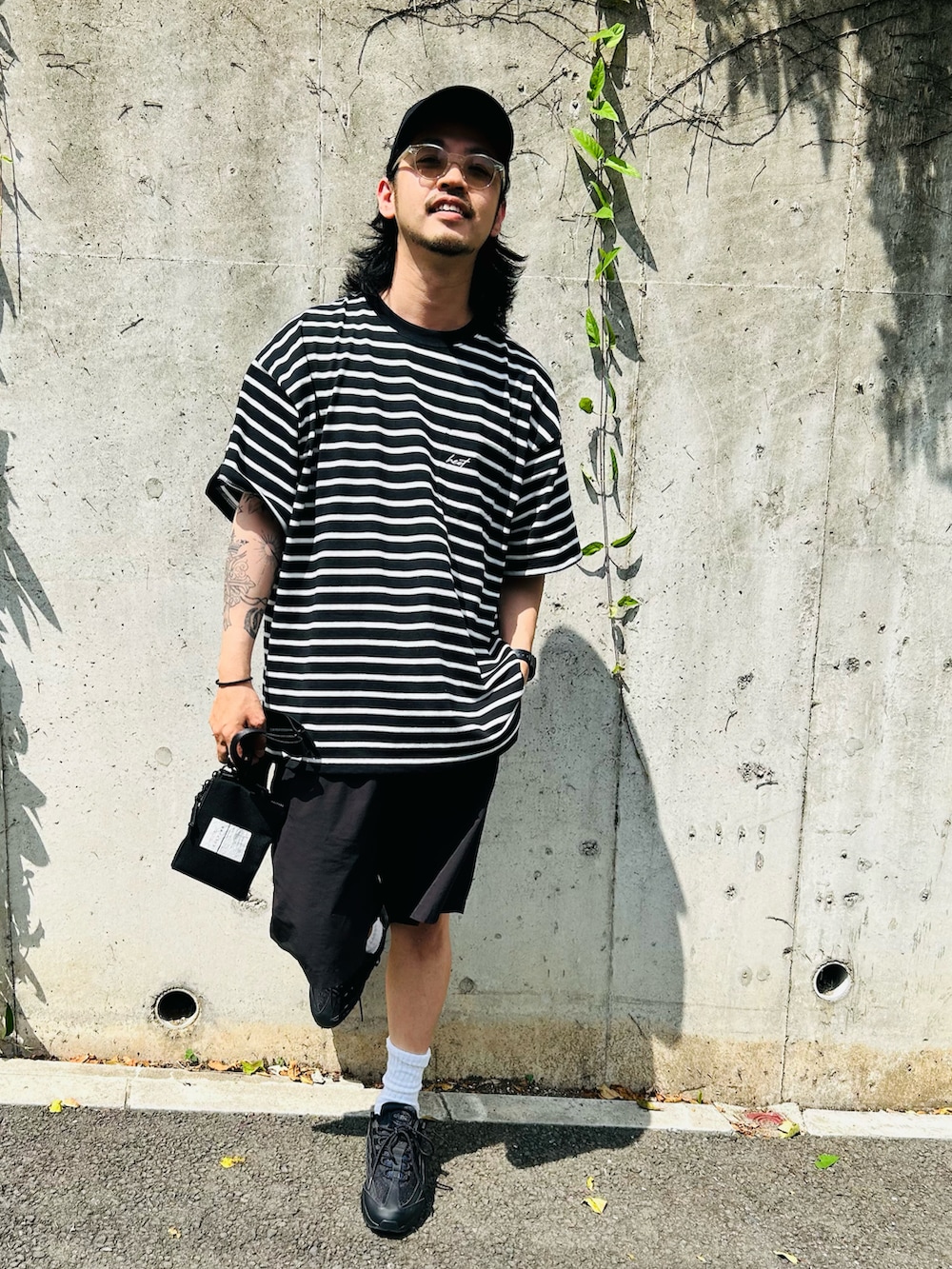 ブラック系のTシャツ/カットソー、ブラック系のパンツ、ブラック系のスニーカーを着用したメンズの夏コーディネートの2枚目の写真