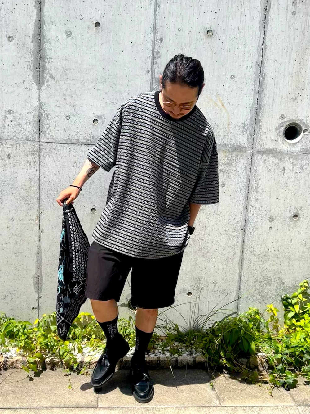 ブラック系のTシャツ/カットソー、ブラック系のパンツ、ブラック系のハットを着用したメンズの夏コーディネートの3枚目の写真