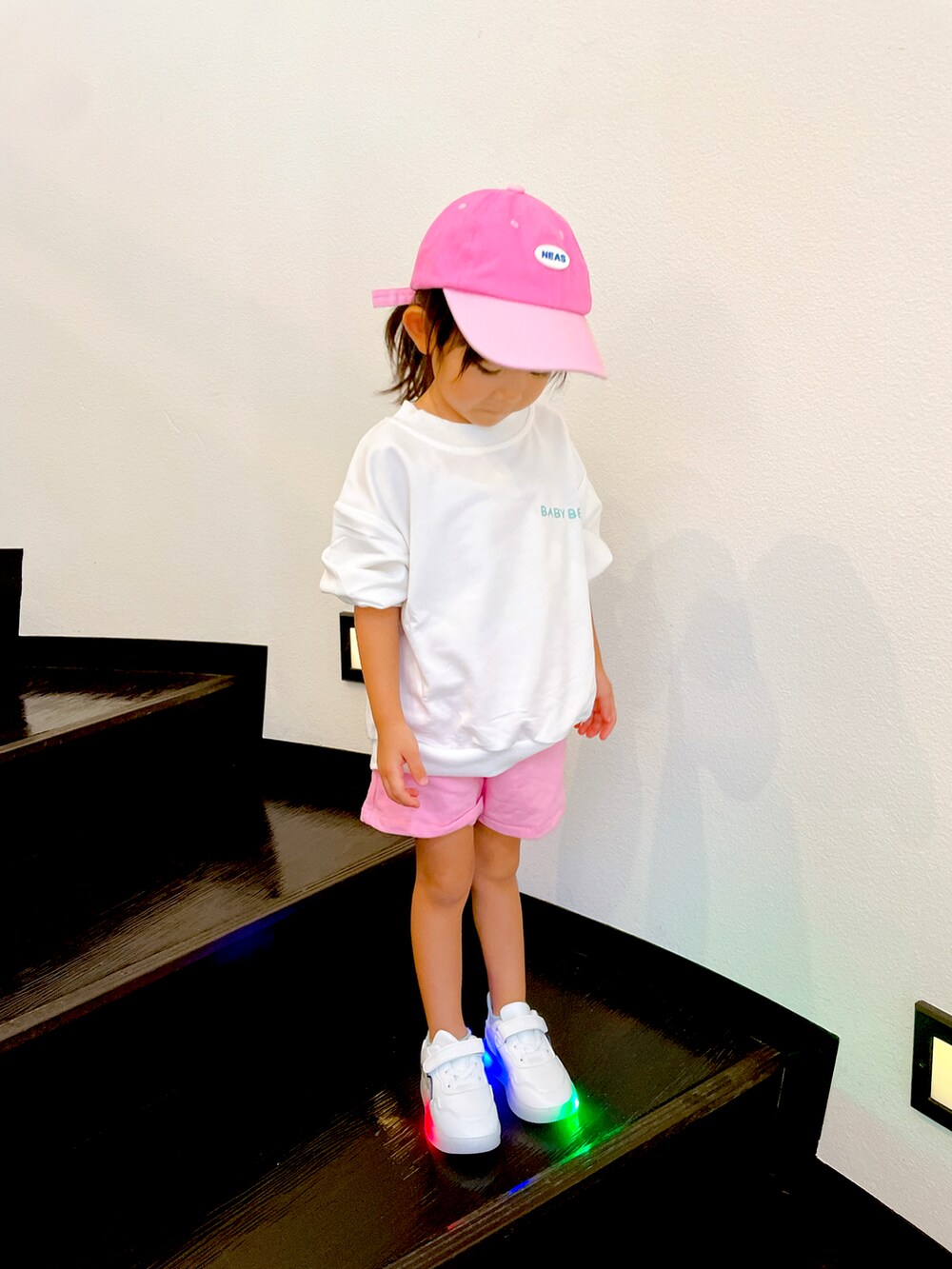 ピンク系のキャップを着用したキッズの秋コーディネートの2枚目の写真