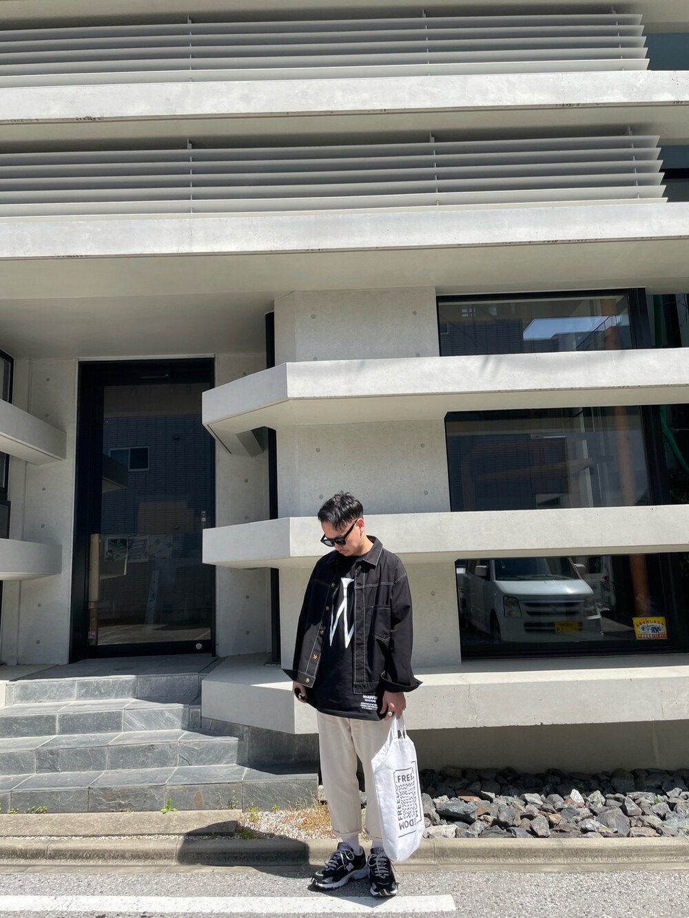 ホワイト系のその他パンツ、ブラック系のスニーカー、その他のトートバッグを着用したメンズの春コーディネートの2枚目の写真