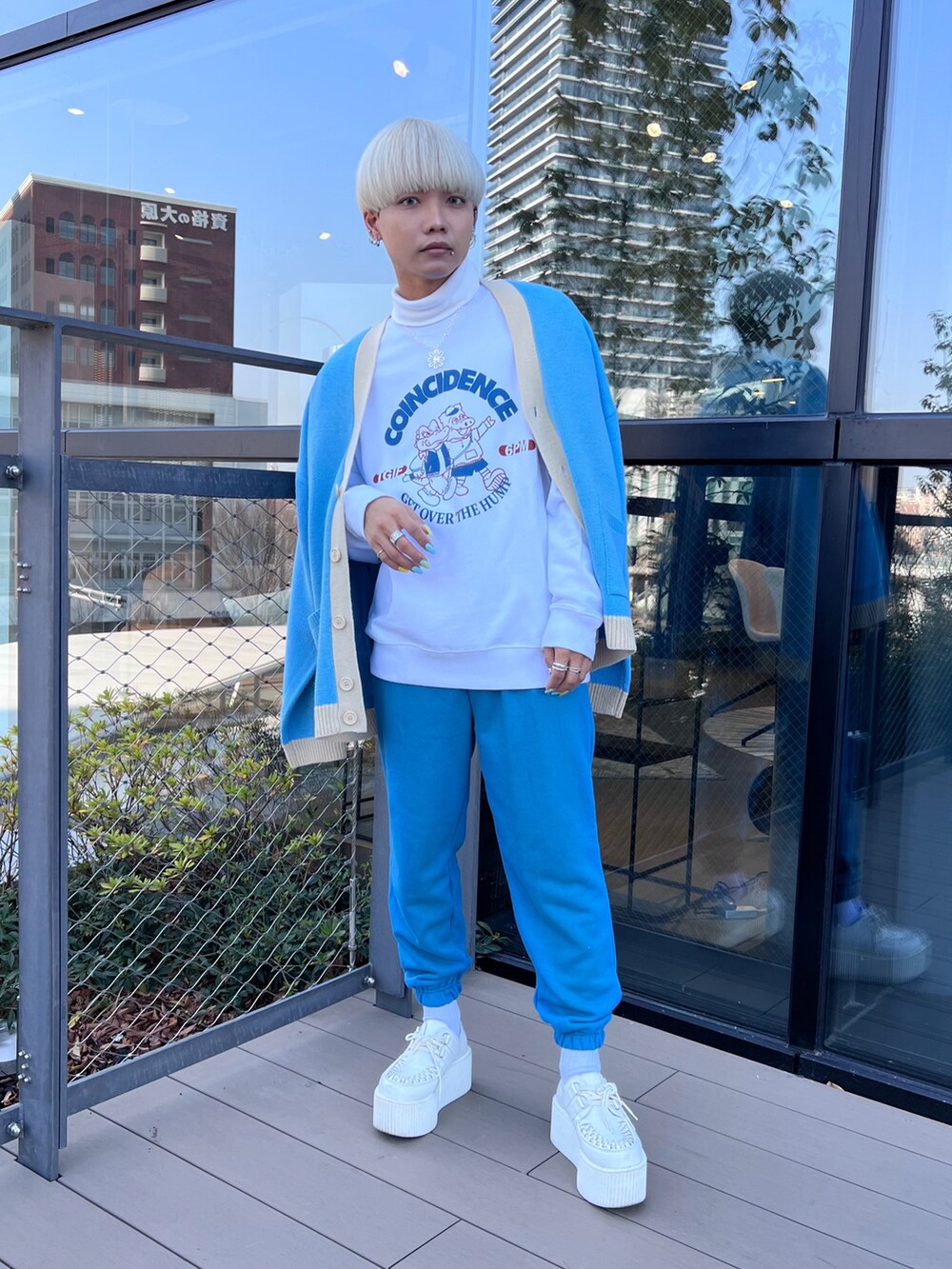 ブルー系のカーディガン/ボレロ、ブルー系のスウェットパンツ、ホワイト系のスニーカーを着用したメンズの冬コーディネートの2枚目の写真