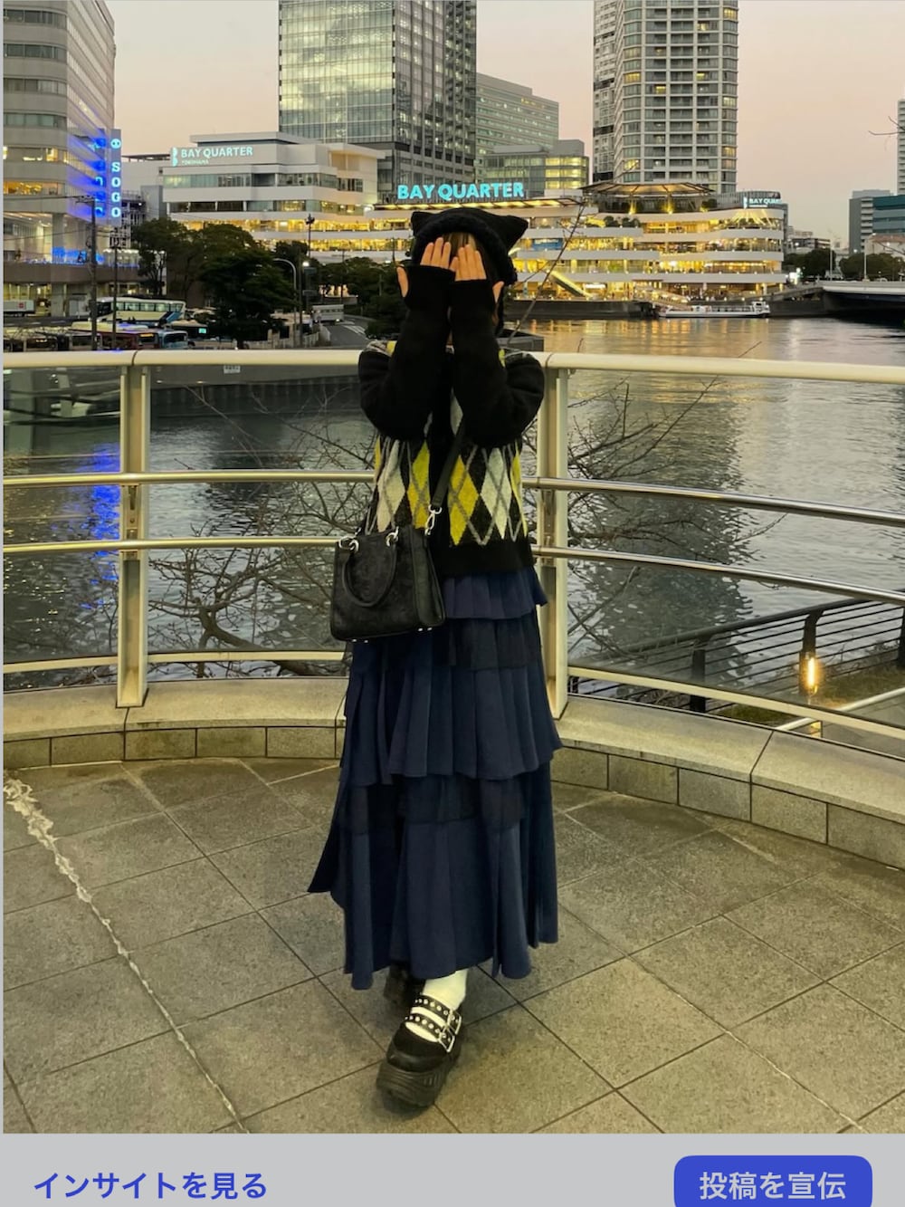 ブラック系のカーディガン/ボレロ、ホワイト系のシャツ/ブラウス、ブルー系のスカートを着用したレディースの冬コーディネートの3枚目の写真