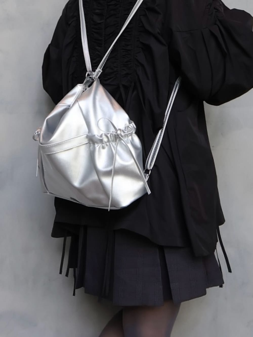 ブラック系のスニーカー、グレー系のスカート、グレー系のシャツ/ブラウスを着用したレディースの春コーディネートの5枚目の写真