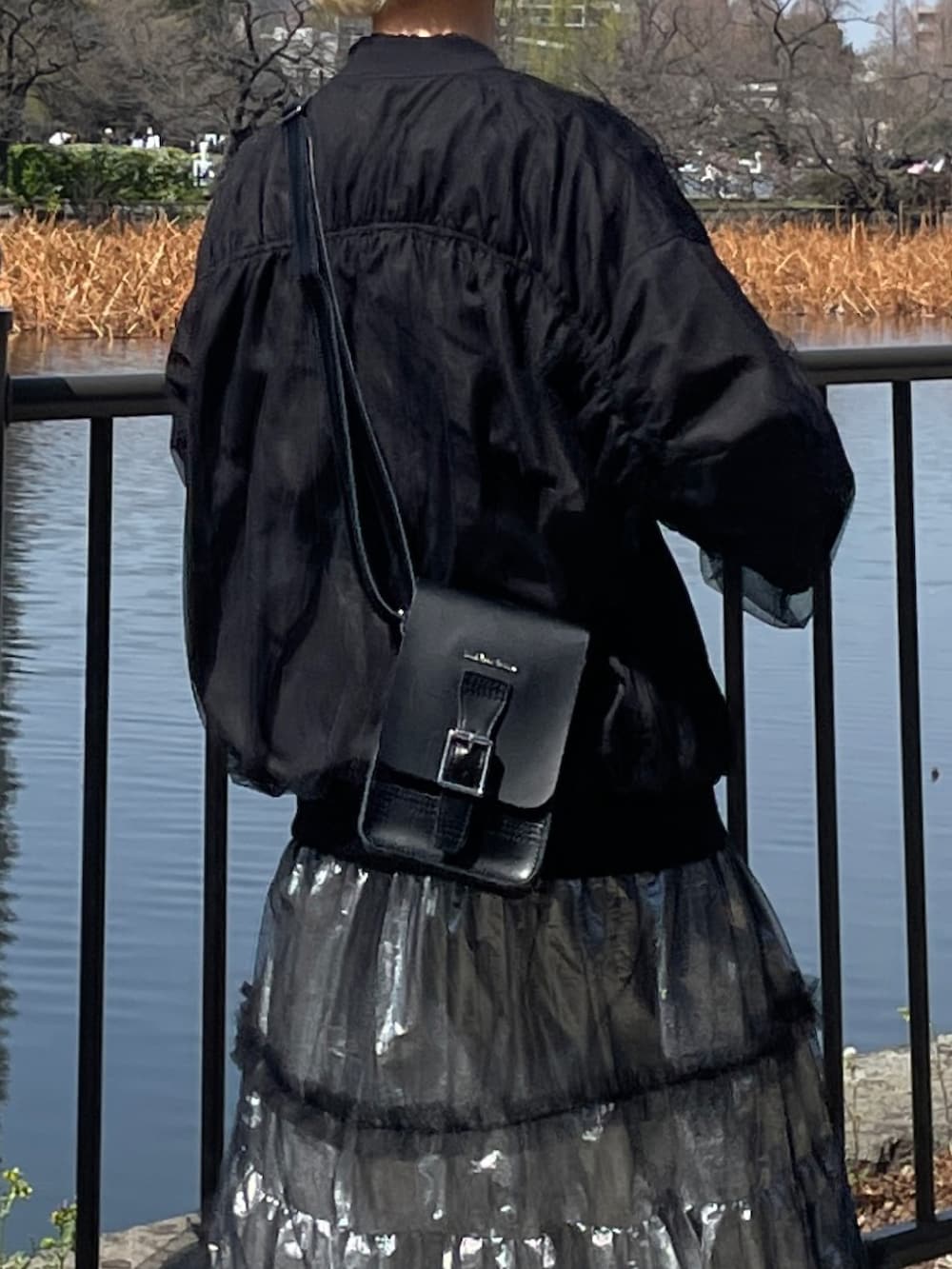 ブラック系のブルゾン、シルバー系のスカート、ブラック系のボディバッグ/ウエストポーチを着用したレディースの春コーディネートの4枚目の写真