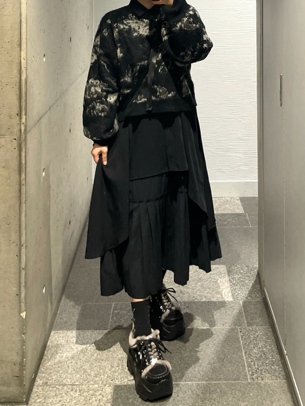 ブラック系のスニーカー、ブラック系のニット/セーター、ブラック系のショルダーバッグを着用したレディースの秋コーディネートの4枚目の写真