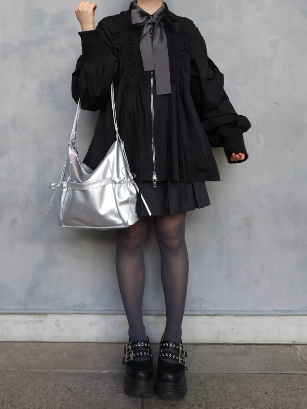 ブラック系のスニーカー、グレー系のスカート、グレー系のシャツ/ブラウスを着用したレディースの春コーディネートの3枚目の写真