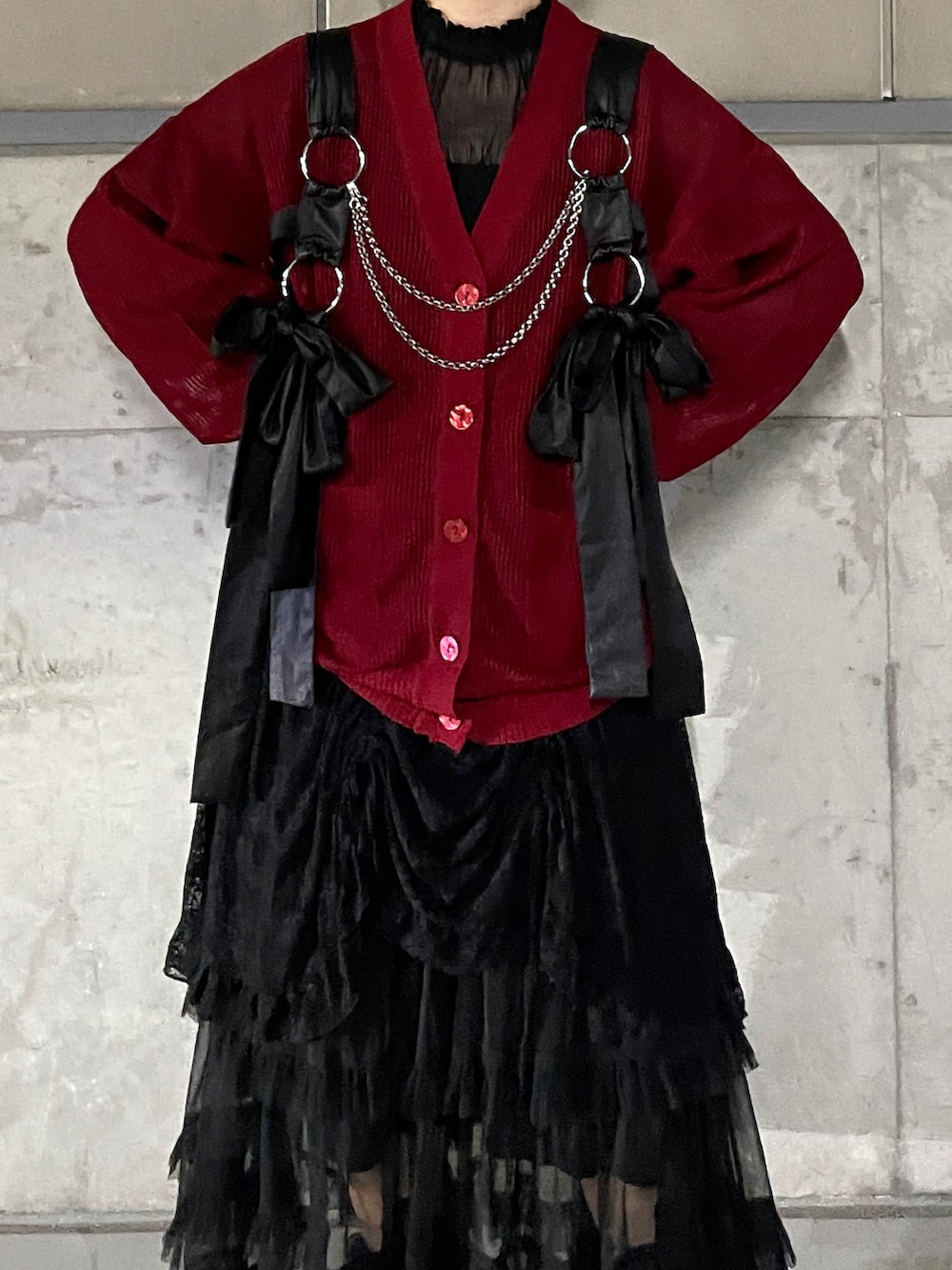 ブラック系のスニーカー、ブラック系のスカート、レッド系のカーディガン/ボレロを着用したレディースの夏コーディネートの2枚目の写真