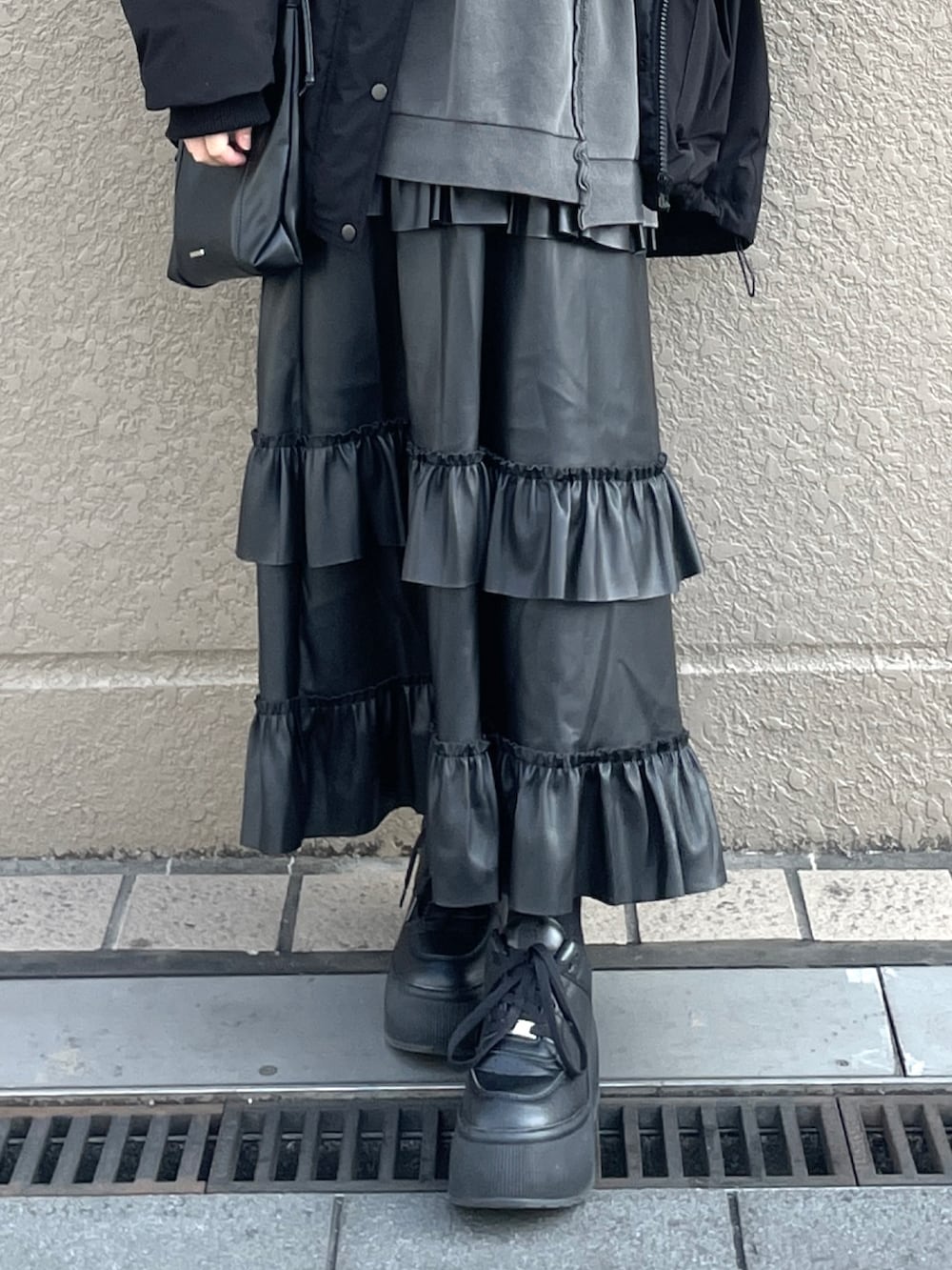 ブラック系のスニーカー、ブラック系のスカート、グレー系のスウェットを着用したレディースの冬コーディネートの3枚目の写真