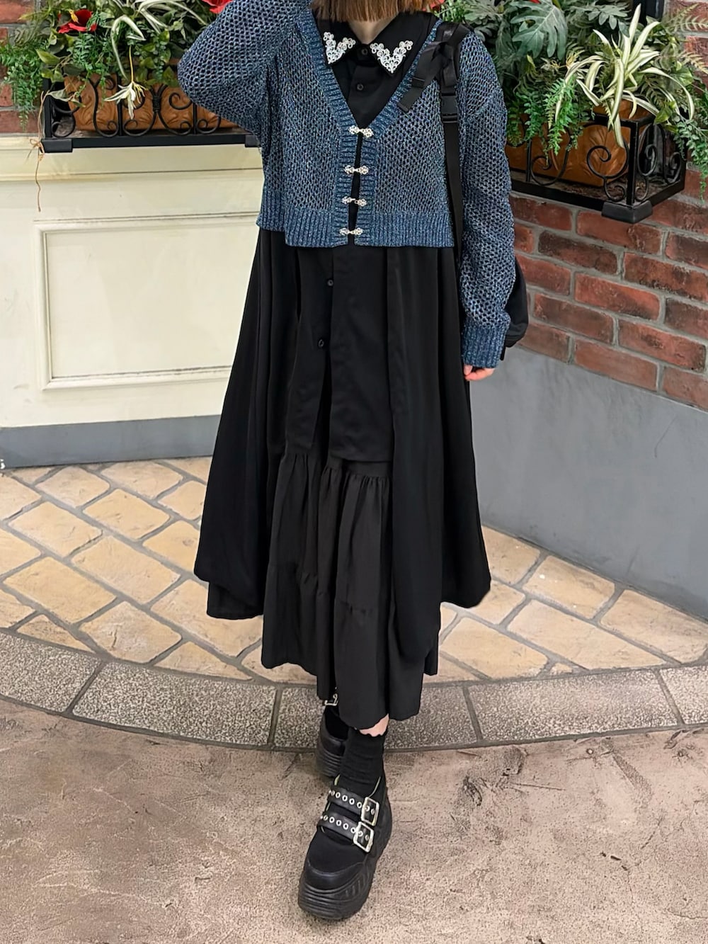ブラック系のスカート、ブラック系のシャツ/ブラウス、ブルー系のカーディガン/ボレロを着用したレディースの春コーディネートの2枚目の写真