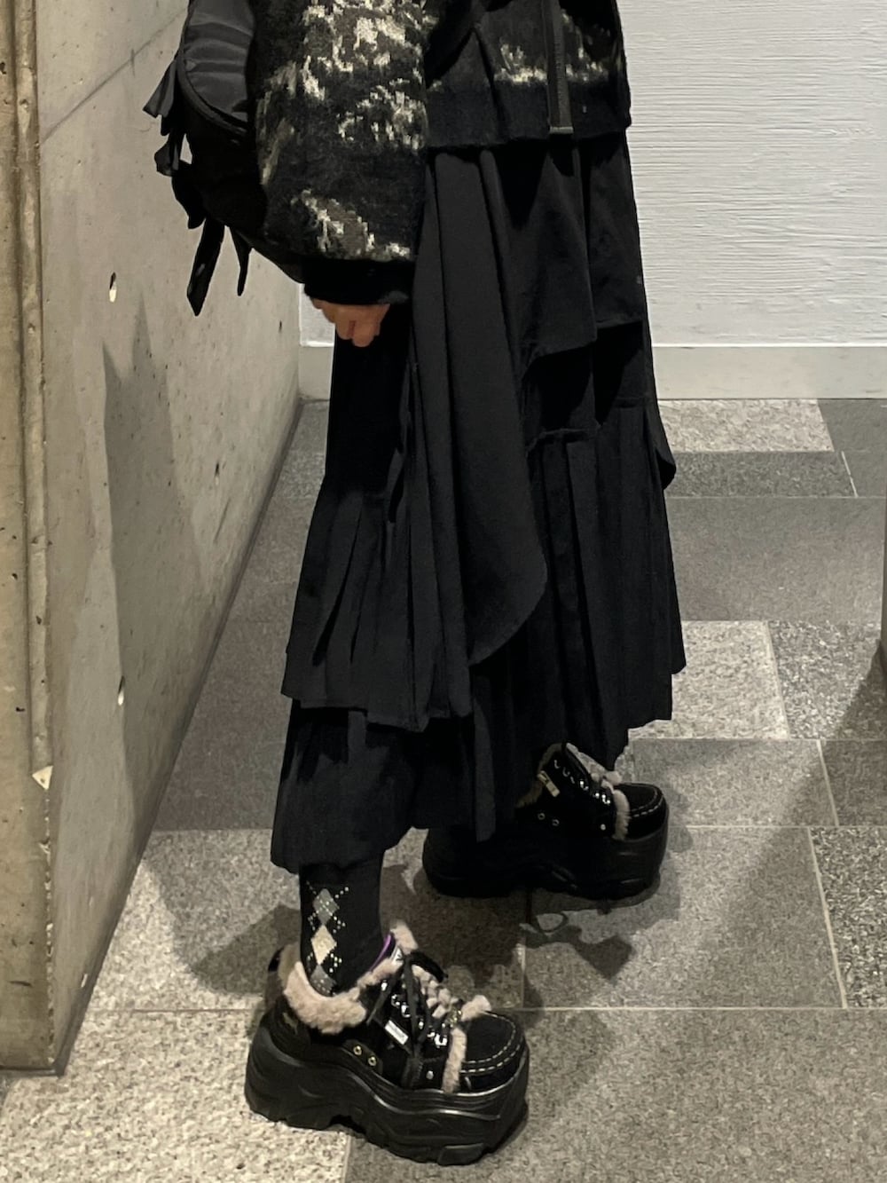 ブラック系のスニーカー、ブラック系のニット/セーター、ブラック系のショルダーバッグを着用したレディースの秋コーディネートの2枚目の写真