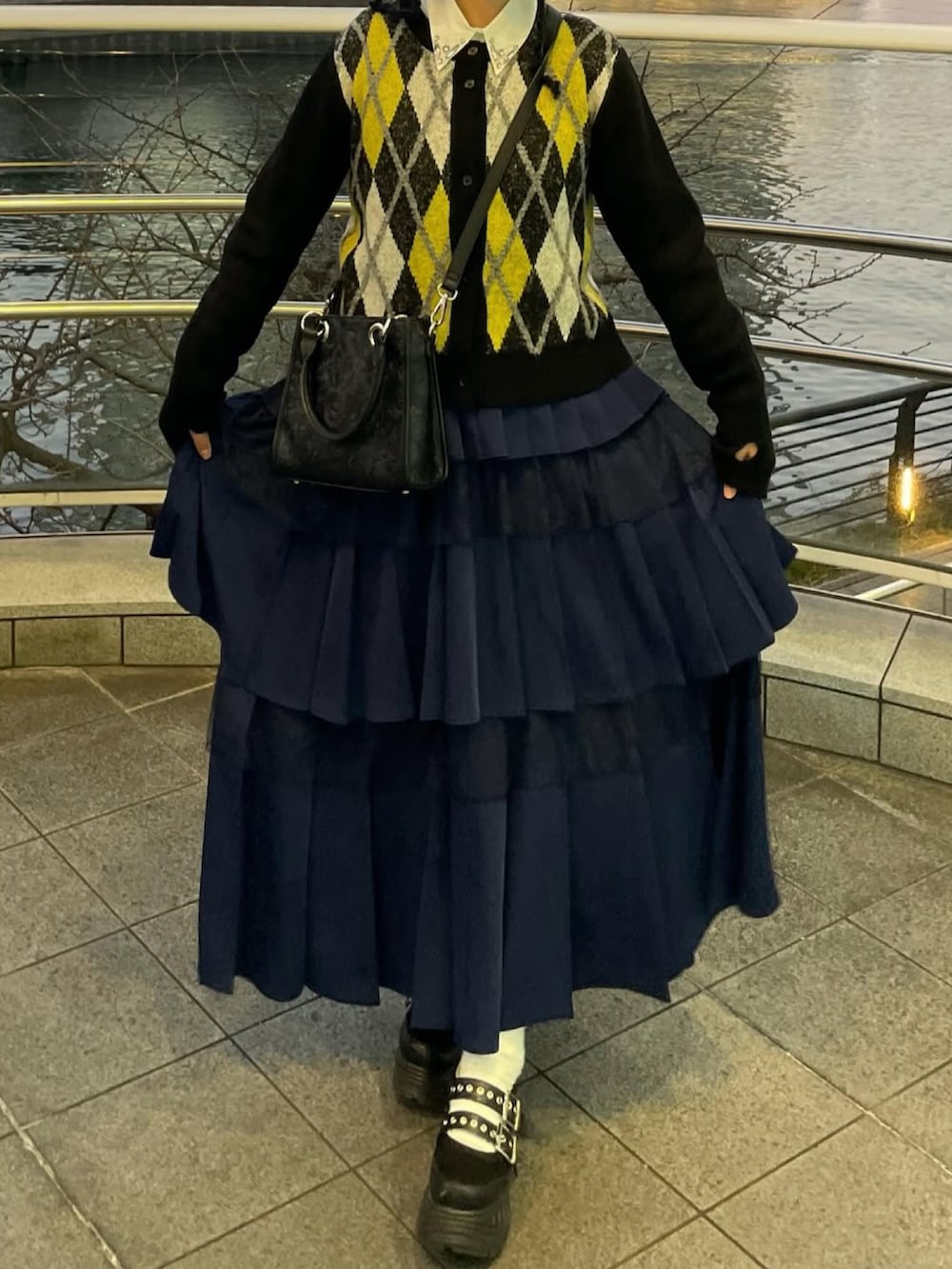 ブラック系のカーディガン/ボレロ、ホワイト系のシャツ/ブラウス、ブルー系のスカートを着用したレディースの冬コーディネートの2枚目の写真