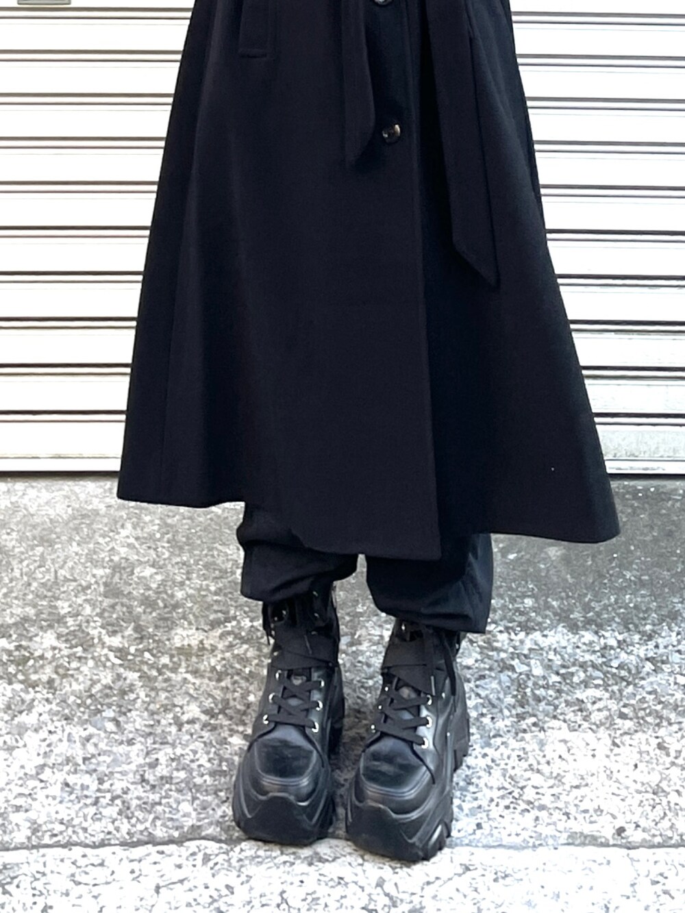 ブラック系のステンカラーコート、グレー系のスウェット、ブラック系のカーゴパンツを着用したレディースの冬コーディネートの2枚目の写真