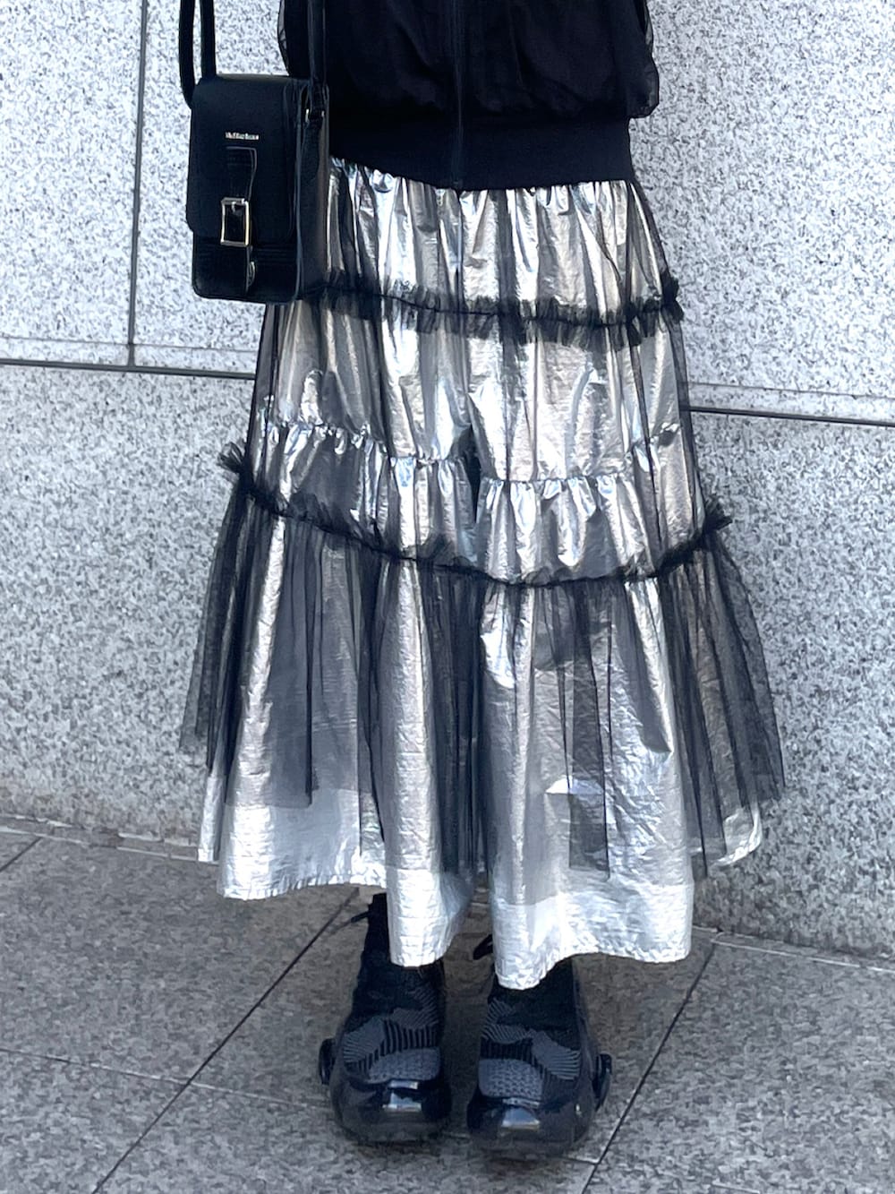 ブラック系のブルゾン、シルバー系のスカート、ブラック系のボディバッグ/ウエストポーチを着用したレディースの春コーディネートの2枚目の写真