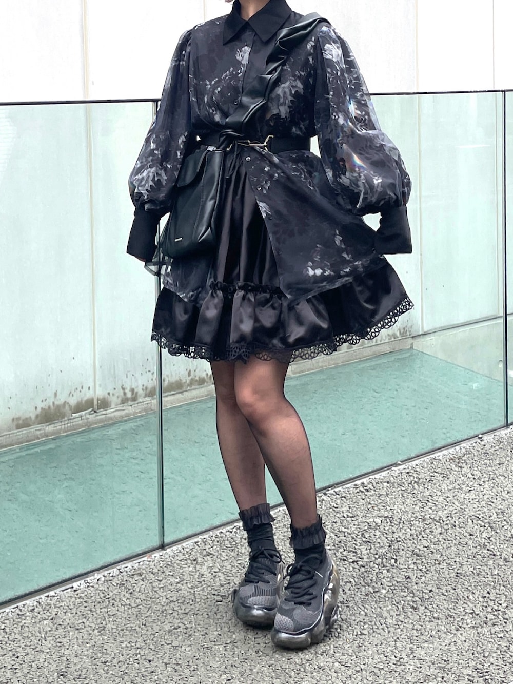 ブラック系のスニーカー、グレー系のシャツ/ブラウス、ブラック系のショルダーバッグを着用したレディースの春コーディネートの2枚目の写真