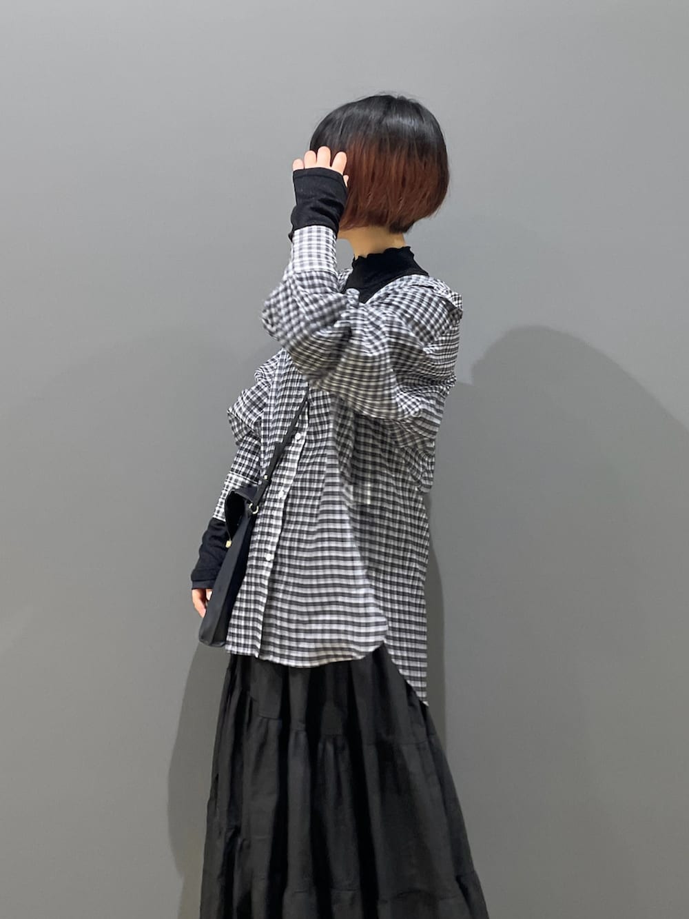 ブラック系のスニーカー、ブラック系のスカート、ブラック系のシャツ/ブラウスを着用したレディースの夏コーディネートの2枚目の写真