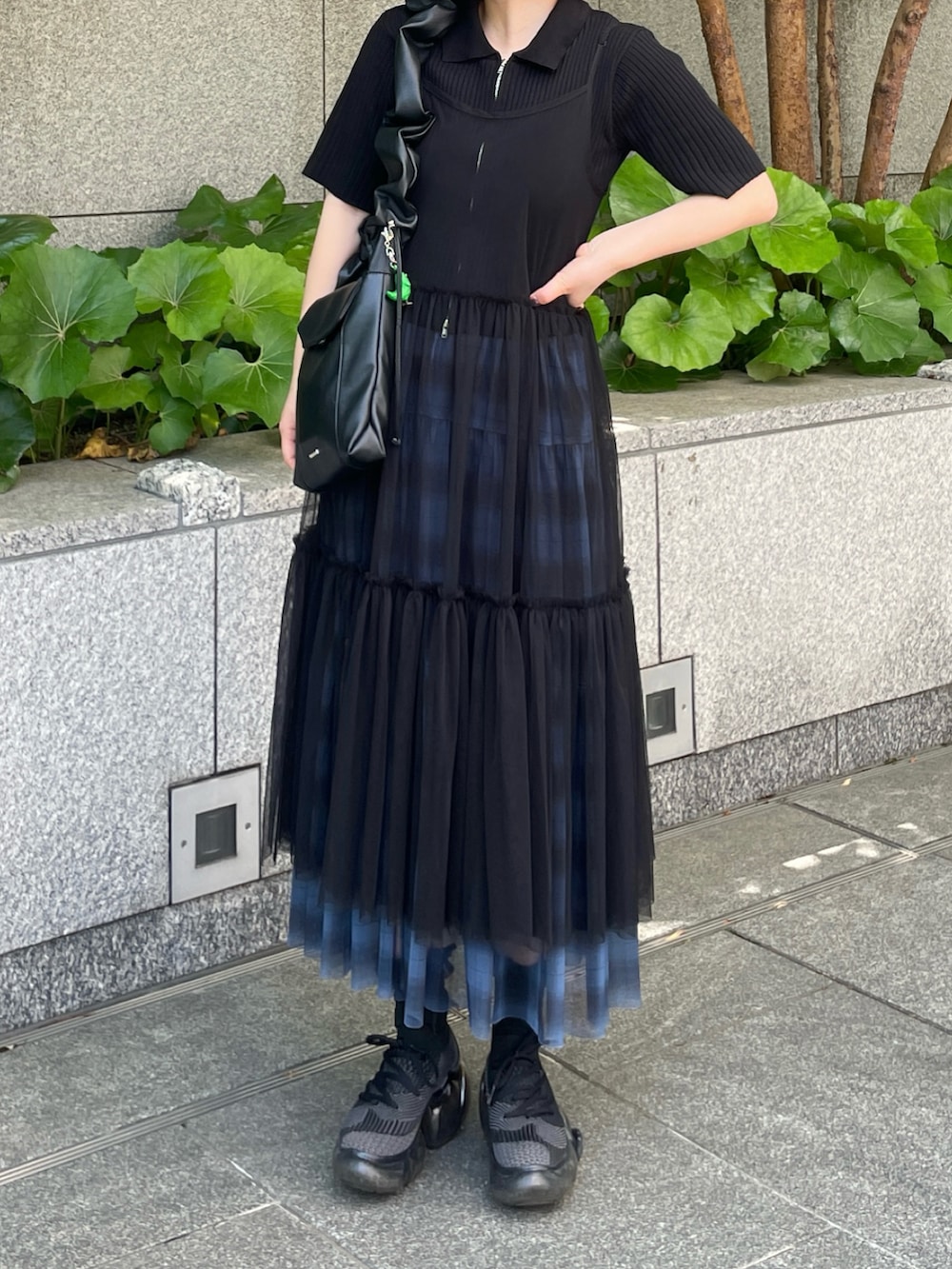 ブラック系のスニーカー、ホワイト系のワンピース/ドレス、ブルー系のスカートを着用したレディースの春コーディネートの2枚目の写真