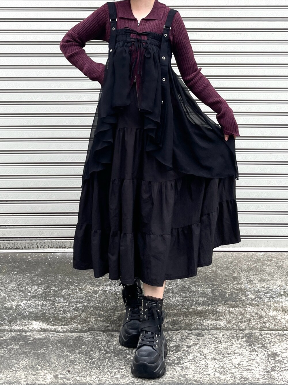レッド系のカーディガン/ボレロ、ブラック系のスカート、ブラック系のブーツを着用したレディースの秋コーディネートの3枚目の写真