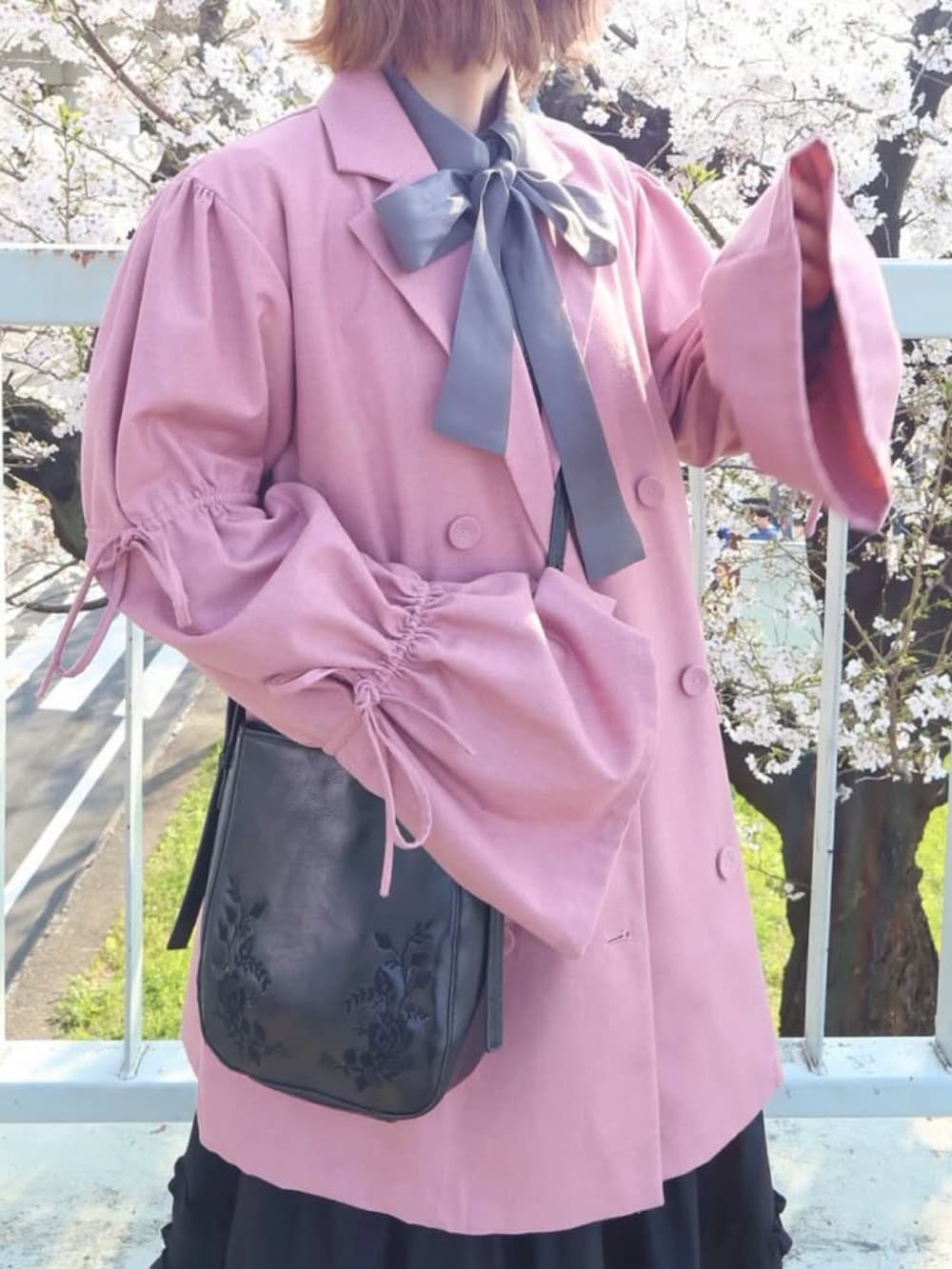 ブラック系のスカート、グレー系のシャツ/ブラウス、ピンク系のテーラードジャケットを着用したレディースの春コーディネートの5枚目の写真