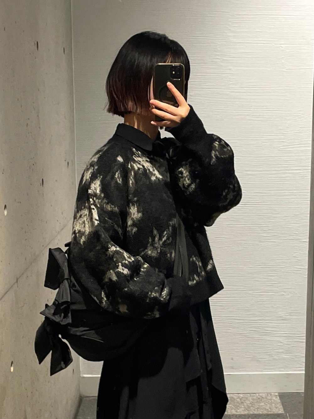 ブラック系のスニーカー、ブラック系のニット/セーター、ブラック系のショルダーバッグを着用したレディースの秋コーディネートの5枚目の写真