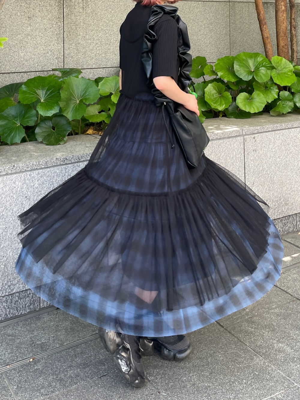 ブラック系のスニーカー、ホワイト系のワンピース/ドレス、ブルー系のスカートを着用したレディースの春コーディネートの4枚目の写真