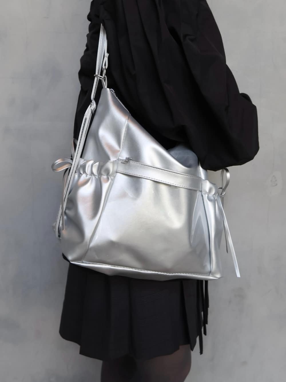 ブラック系のスニーカー、グレー系のスカート、グレー系のシャツ/ブラウスを着用したレディースの春コーディネートの4枚目の写真