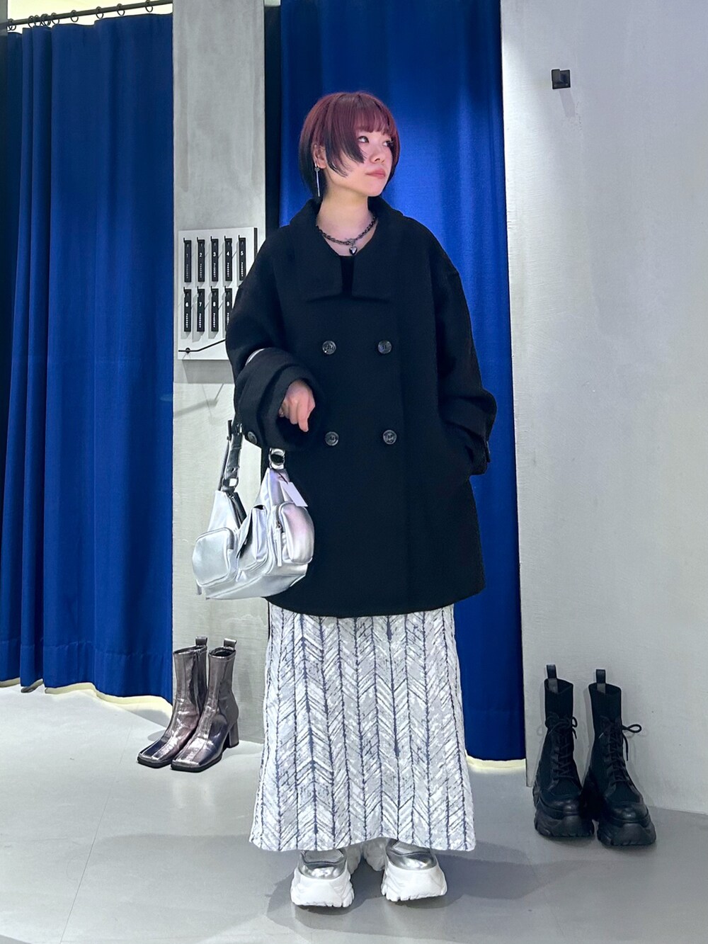ブラック系のテーラードジャケット、シルバー系のショルダーバッグ、ブルー系のスカートを着用したレディースの秋コーディネートの5枚目の写真