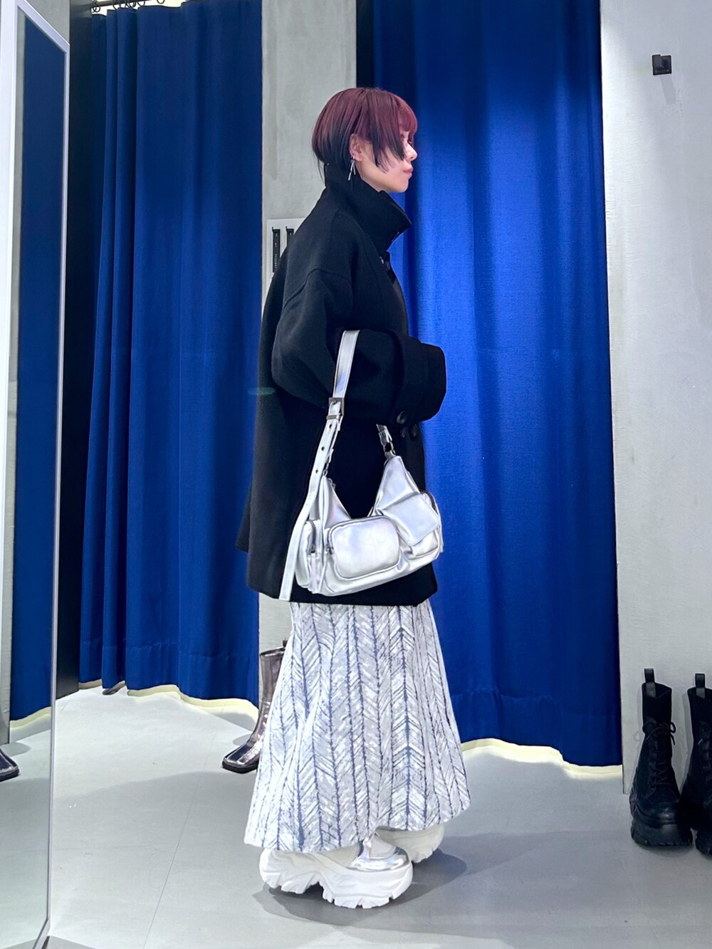 ブラック系のテーラードジャケット、シルバー系のショルダーバッグ、ブルー系のスカートを着用したレディースの秋コーディネートの2枚目の写真
