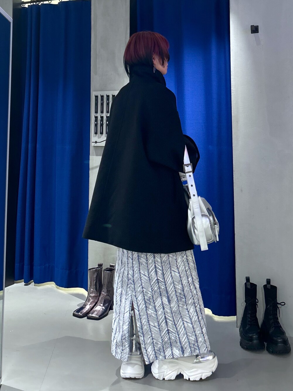 ブラック系のテーラードジャケット、シルバー系のショルダーバッグ、ブルー系のスカートを着用したレディースの秋コーディネートの3枚目の写真