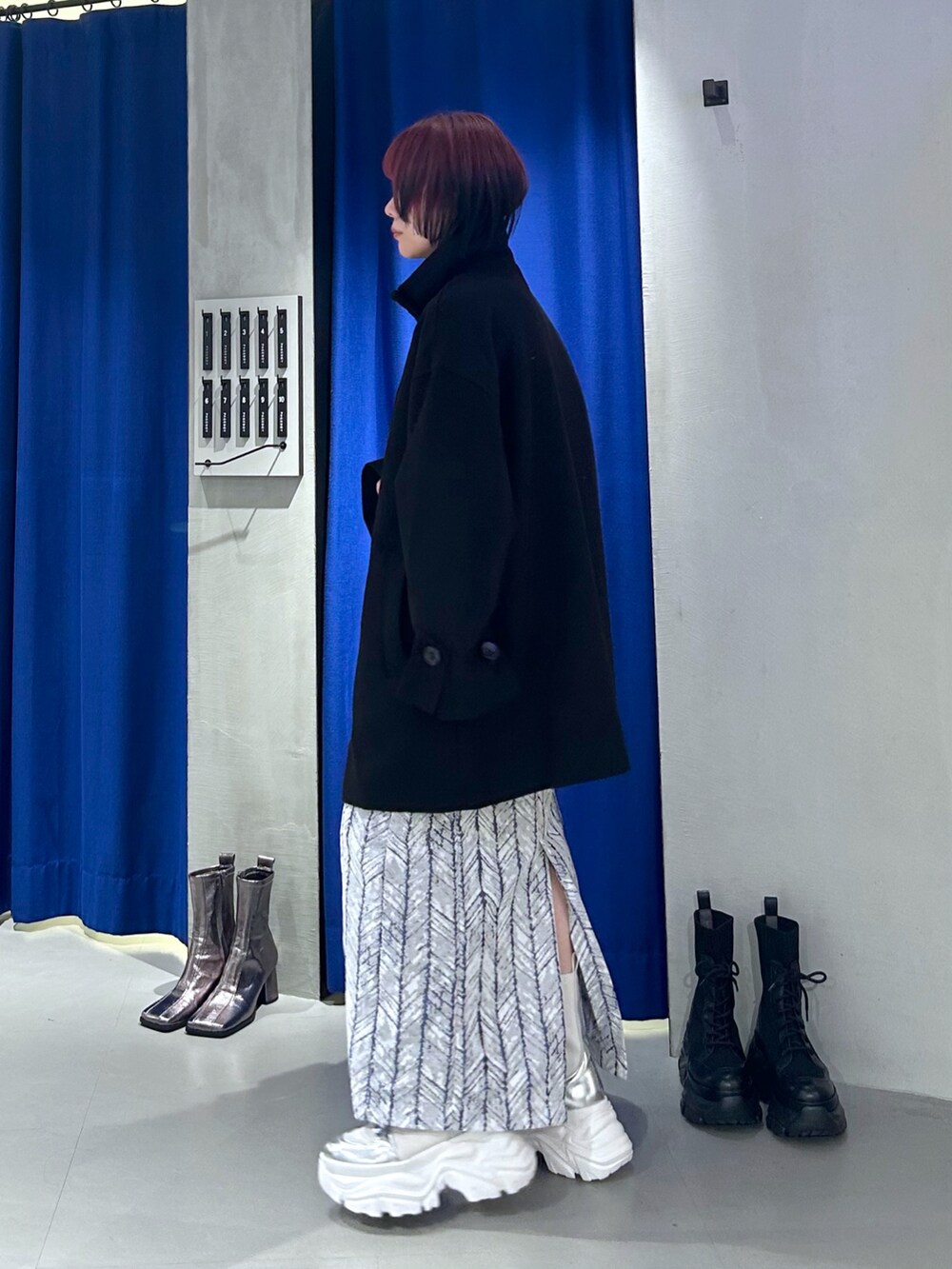 ブラック系のテーラードジャケット、シルバー系のショルダーバッグ、ブルー系のスカートを着用したレディースの秋コーディネートの4枚目の写真