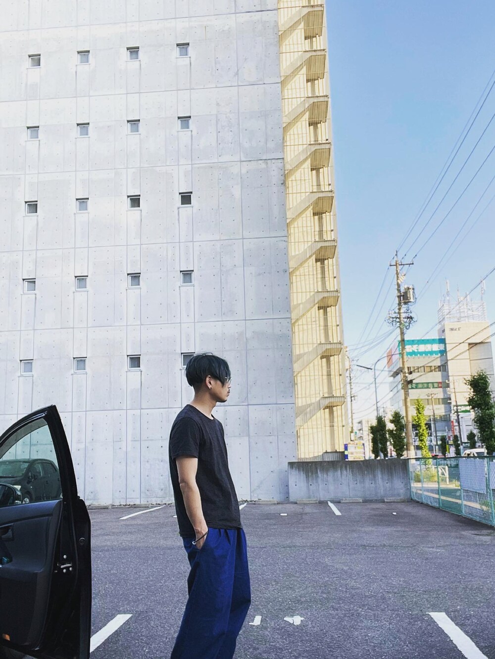 ブルー系のデニムパンツ、ブラック系のTシャツ/カットソーを着用したメンズの夏コーディネートの2枚目の写真