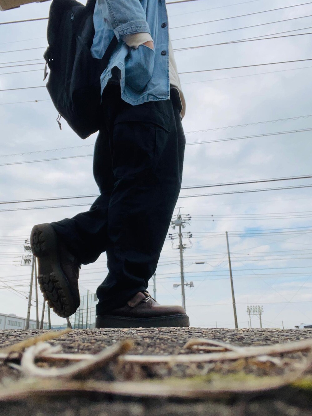 ブルー系のシャツ/ブラウス、ブラック系のカーゴパンツ、ブラウン系のブーツを着用したメンズの春コーディネートの2枚目の写真