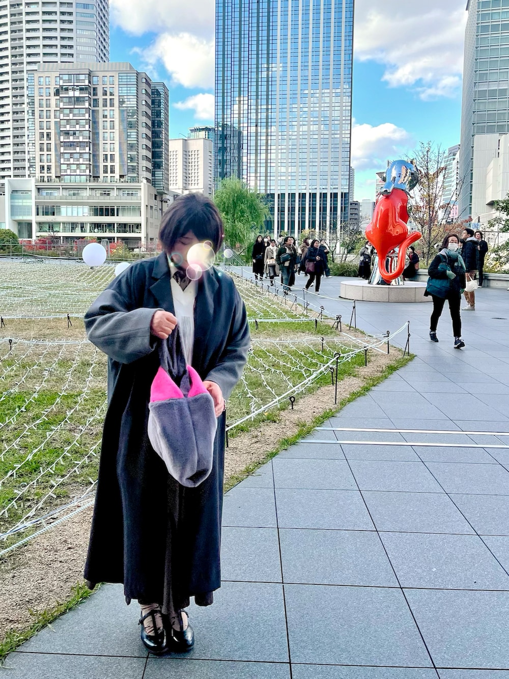 グレー系のチェスターコート、ホワイト系のベスト、ベージュ系のシャツ/ブラウスを着用したレディースの冬コーディネートの2枚目の写真