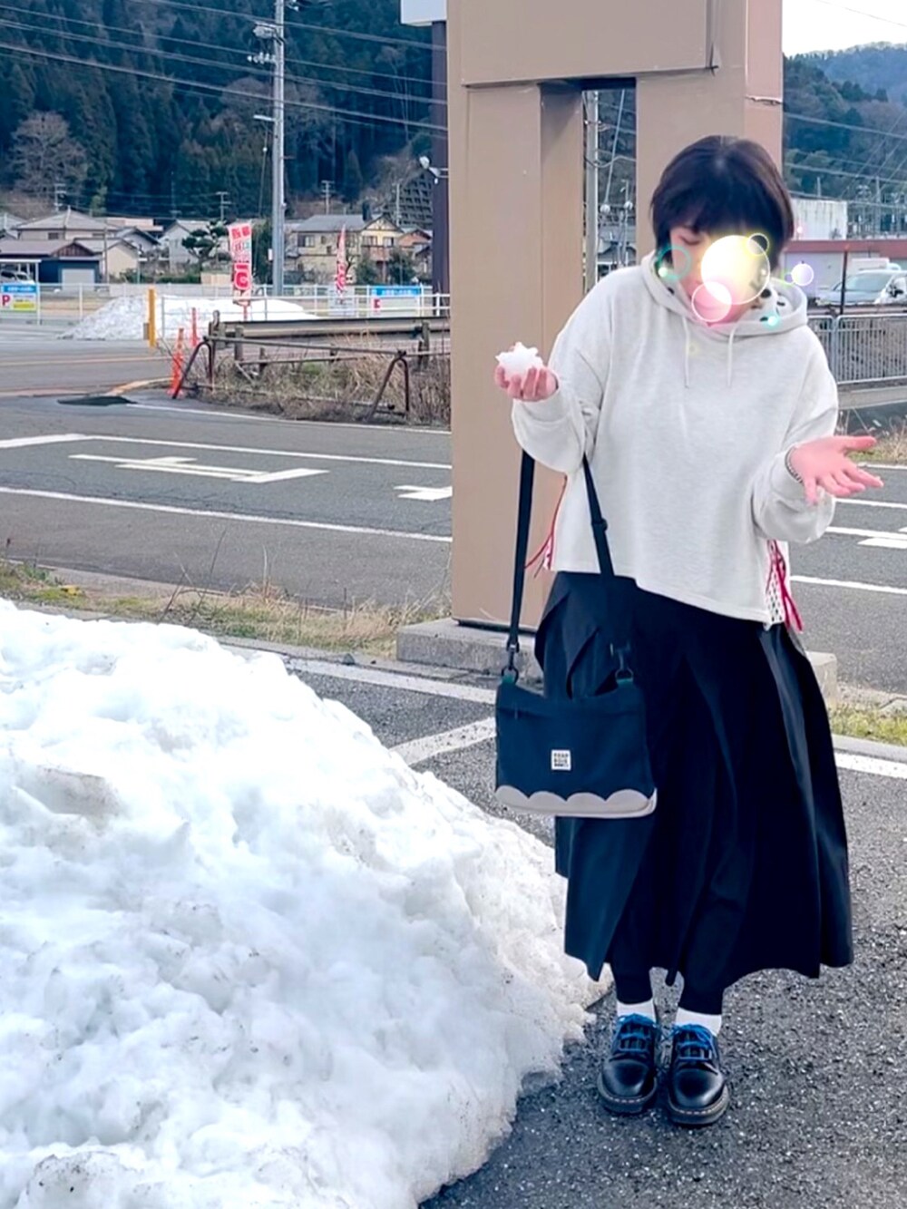 ベージュ系のパーカー、ブラック系のスカート、ブラック系のショルダーバッグを着用したレディースの冬コーディネートの2枚目の写真