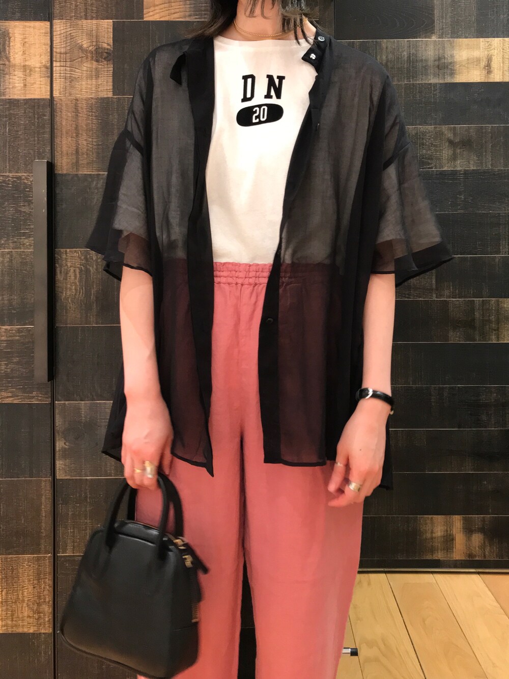 ホワイト系のTシャツ/カットソー、ブラック系のシャツ/ブラウス、ブラック系のハンドバッグを着用したレディースの夏コーディネートの2枚目の写真