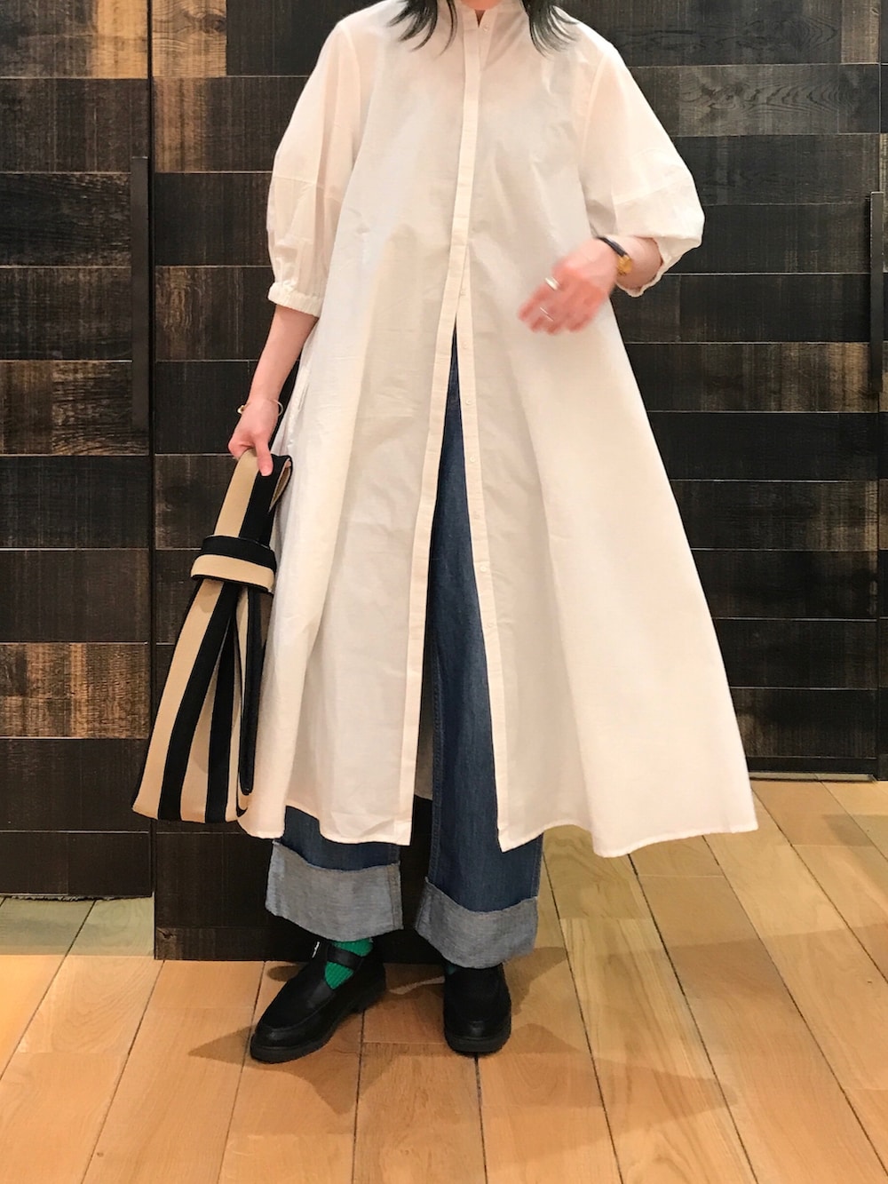 ホワイト系のワンピース、ブルー系のデニムパンツを着用したレディースの春コーディネートの2枚目の写真