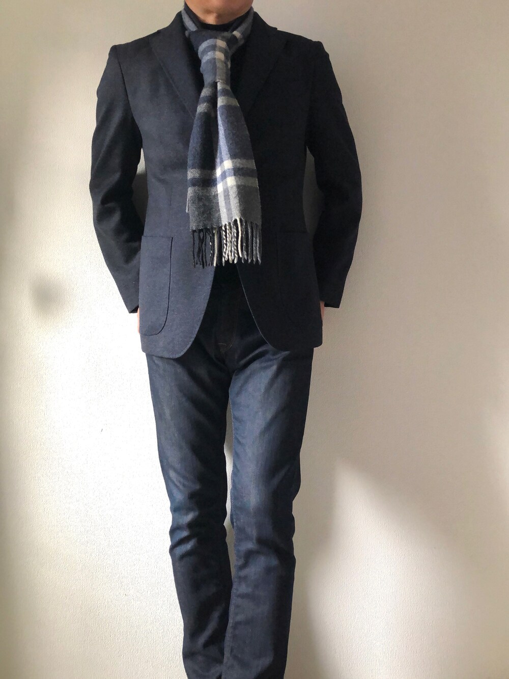 ブルー系のデニムパンツ、ブルー系のテーラードジャケット、ブラック系のニット/セーターを着用したメンズの冬コーディネートの2枚目の写真