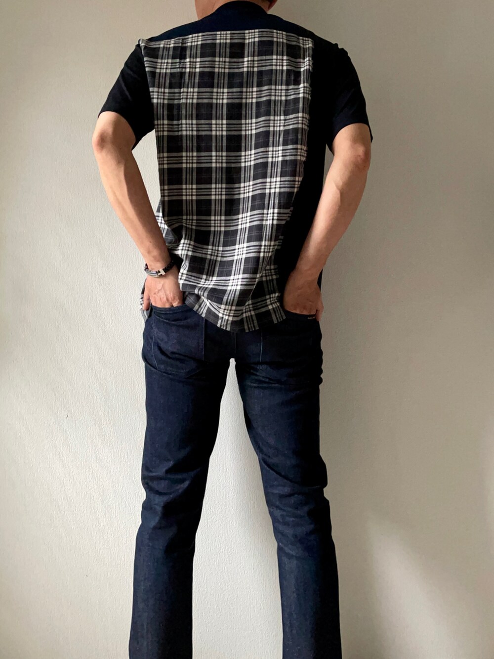 ブラック系のTシャツ/カットソー、ブルー系のデニムパンツ、ホワイト系のスニーカーを着用したメンズの春コーディネートの3枚目の写真