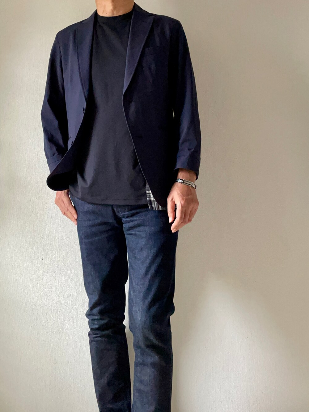 ブラック系のTシャツ/カットソー、ブルー系のデニムパンツ、ホワイト系のスニーカーを着用したメンズの春コーディネートの2枚目の写真