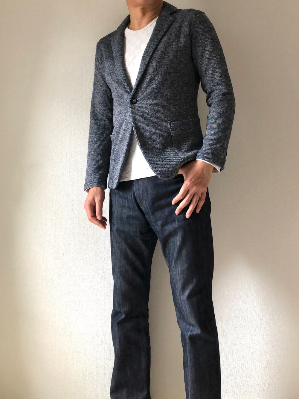 ホワイト系のTシャツ/カットソー、ブルー系のデニムパンツ、ブラック系のスニーカーを着用したメンズの春コーディネートの2枚目の写真