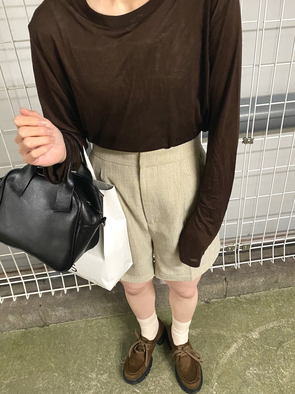 グレー系のその他パンツ、ブラウン系のモカシン/デッキシューズ、ブラック系のトートバッグを着用したレディースの秋コーディネートの2枚目の写真